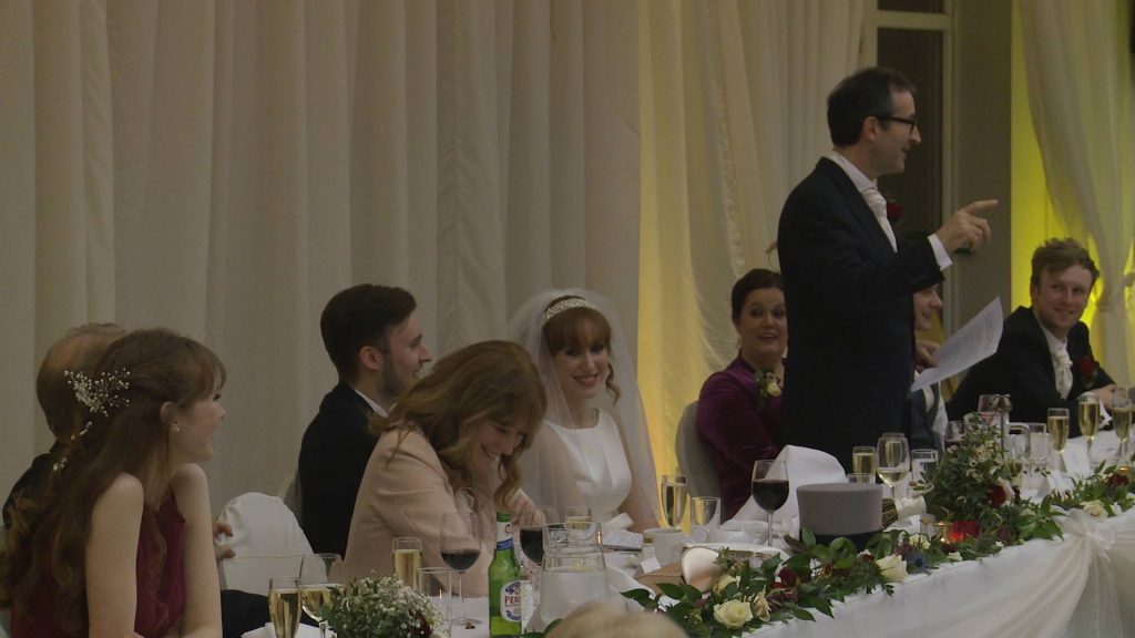 the bride and her mum smile as the father of the bride delivers his wedding speech at a wedding in The Villa Wrea Green