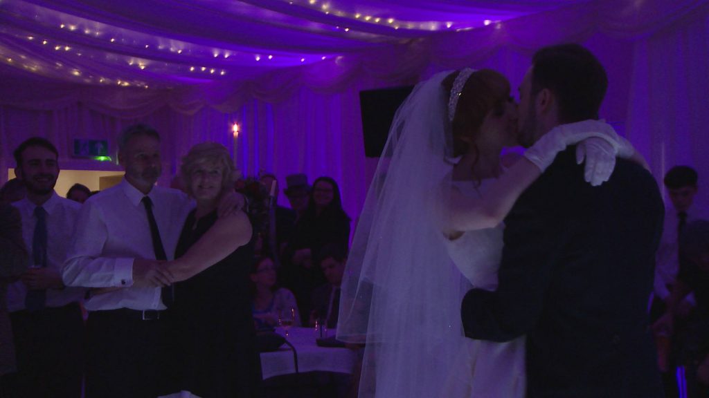 the bride and groom enjoy their first dance on a white dance floor at the villa wrea green