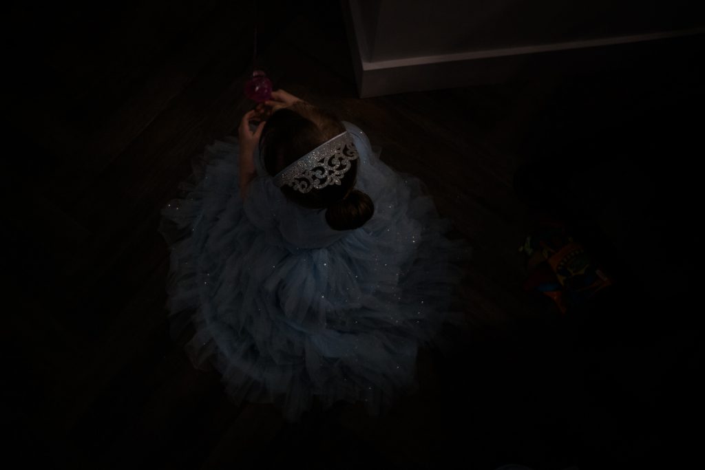a family photograph from above of a 4 year old little girl sat on the floor in her cinderella princess dress and silver crown with her hair tied in a bun in the fat italian near Burscough