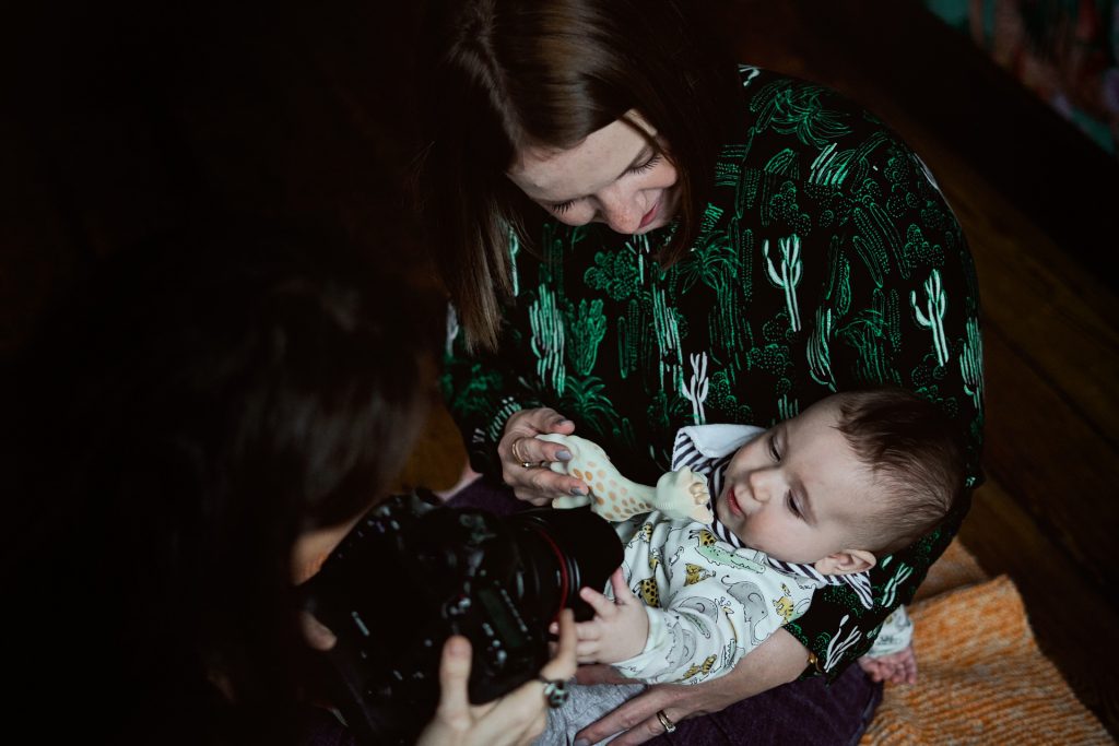 anna hardy gets in close to a mum and her baby to demonstrate how she photographs families during her family shoots in Manchester
