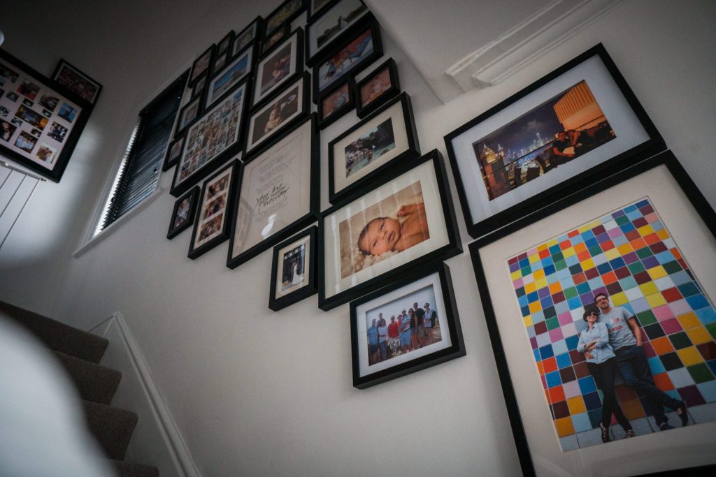 family photo wall inspiration. looking up the stairs there are lots of framed family photos using a black and white colour scheme giving it a modern feel for framing family photographs in Lancashire