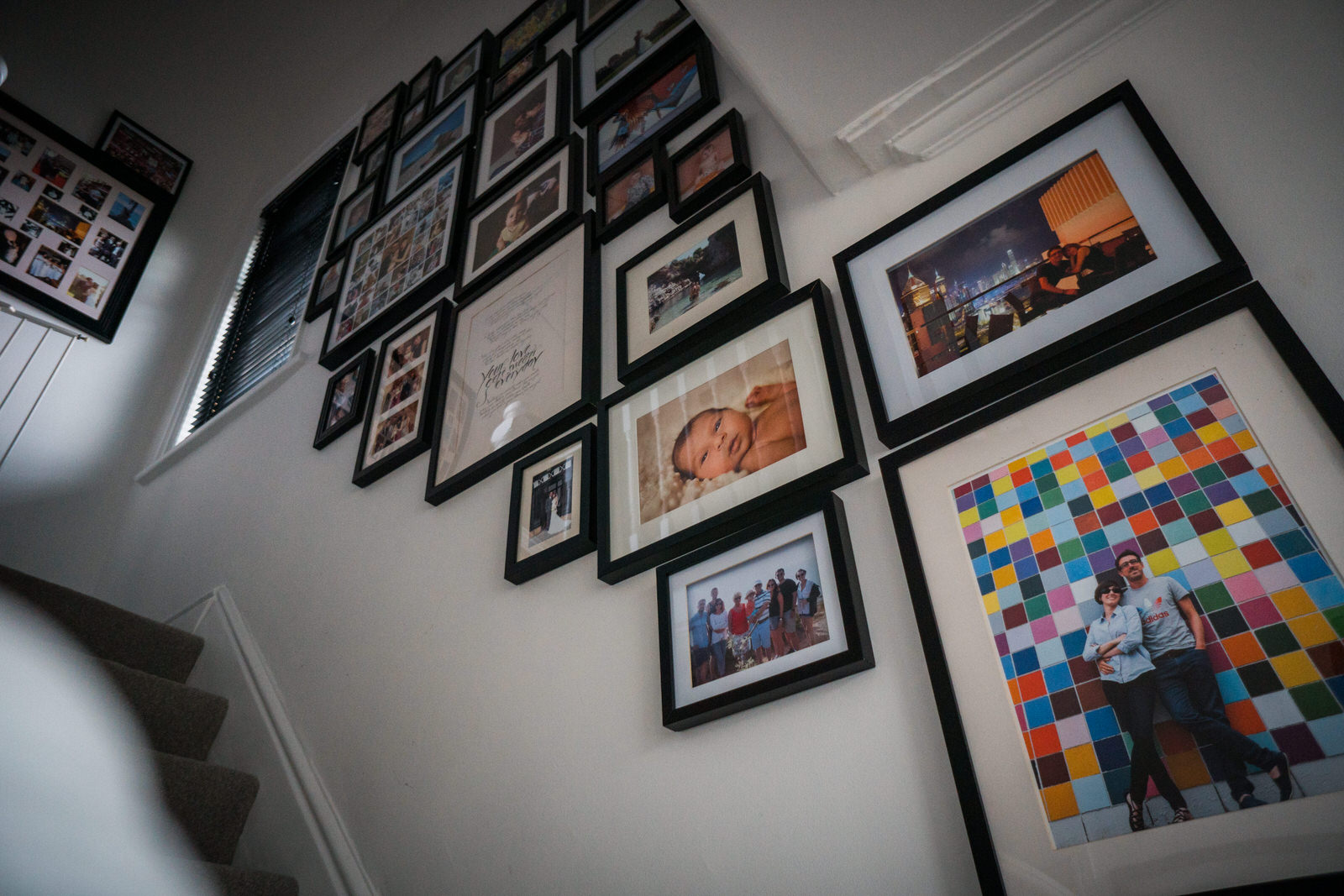 family photo wall inspiration. looking up the stairs there are lots of framed family photos using a black and white colour scheme giving it a modern feel for framing family photographs in Lancashire
