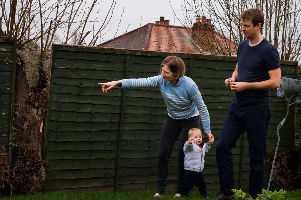 a mum points one way and her daughter another as they decide where to explore next during an outdoor family photoshoot in Hale