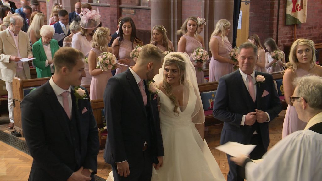 a wirral wedding videographer filmed the bride and grooms first look and smile at their wedding at Oxton St Saviours in Wirral