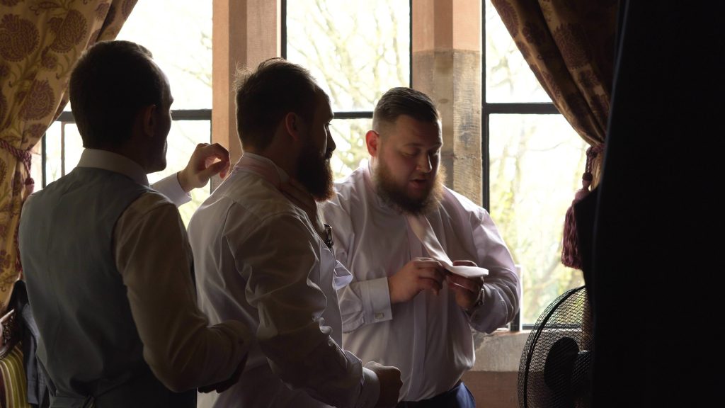 a still from the wedding video of the groom and groomsmen getting ready at Peckforton Castle