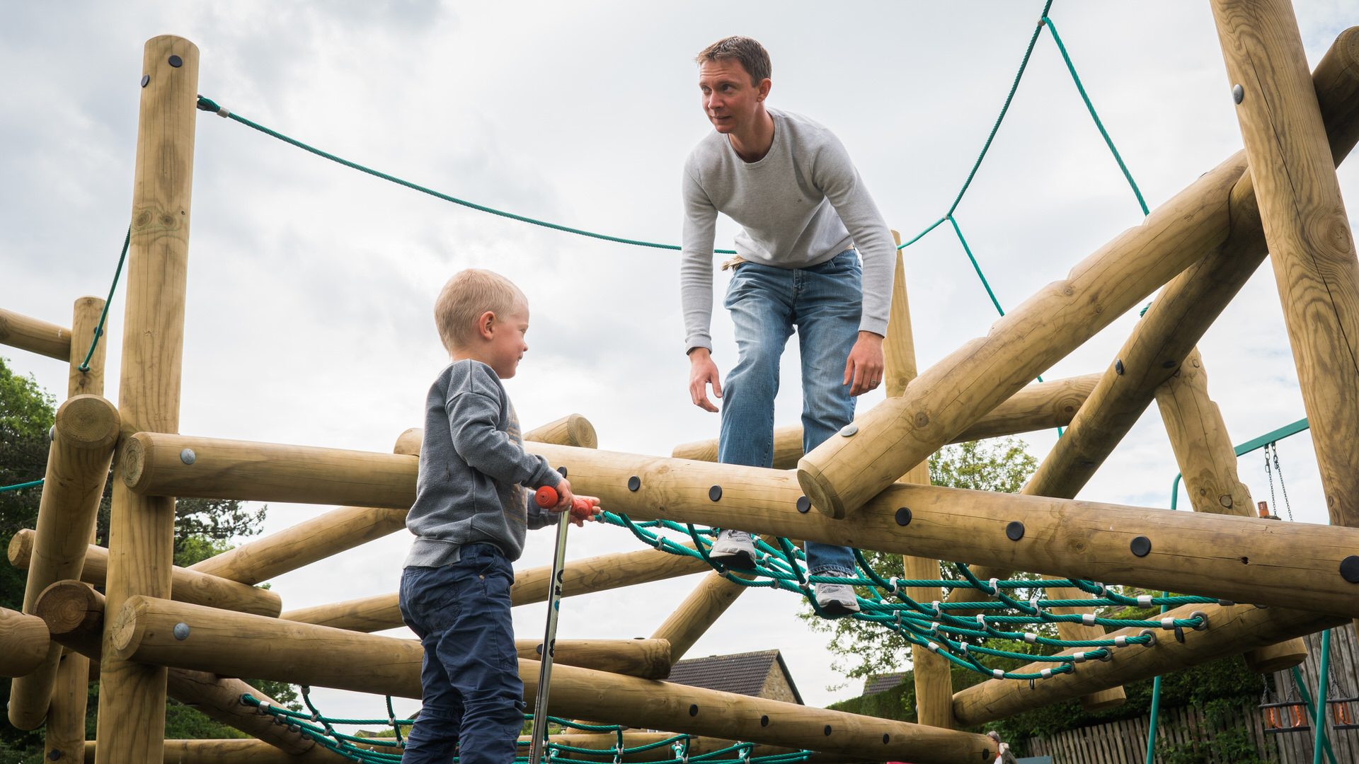 a dad and boy play on climbing frame at a local park in Wetherby