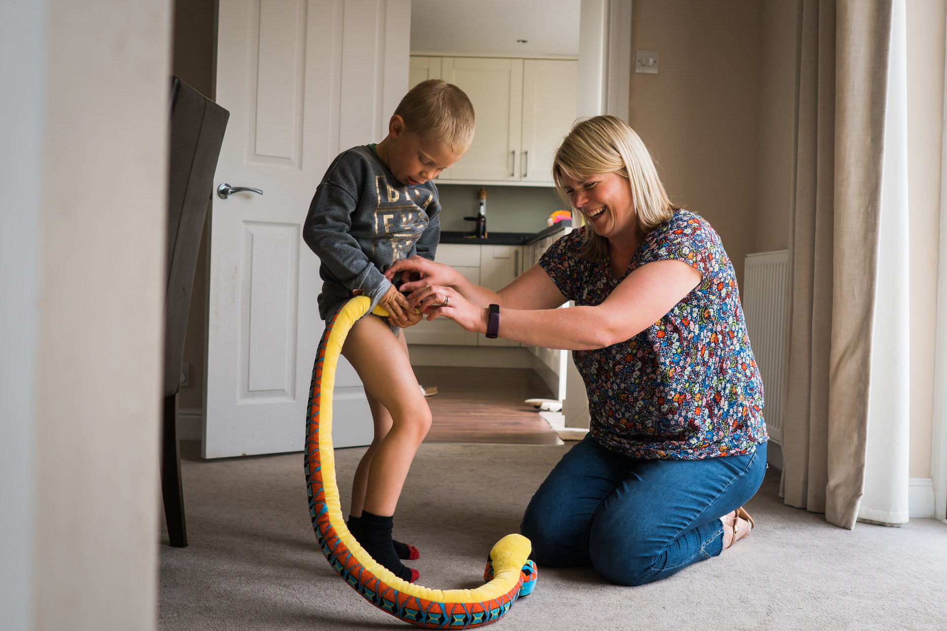 a mum laughs with her son during a family shoot