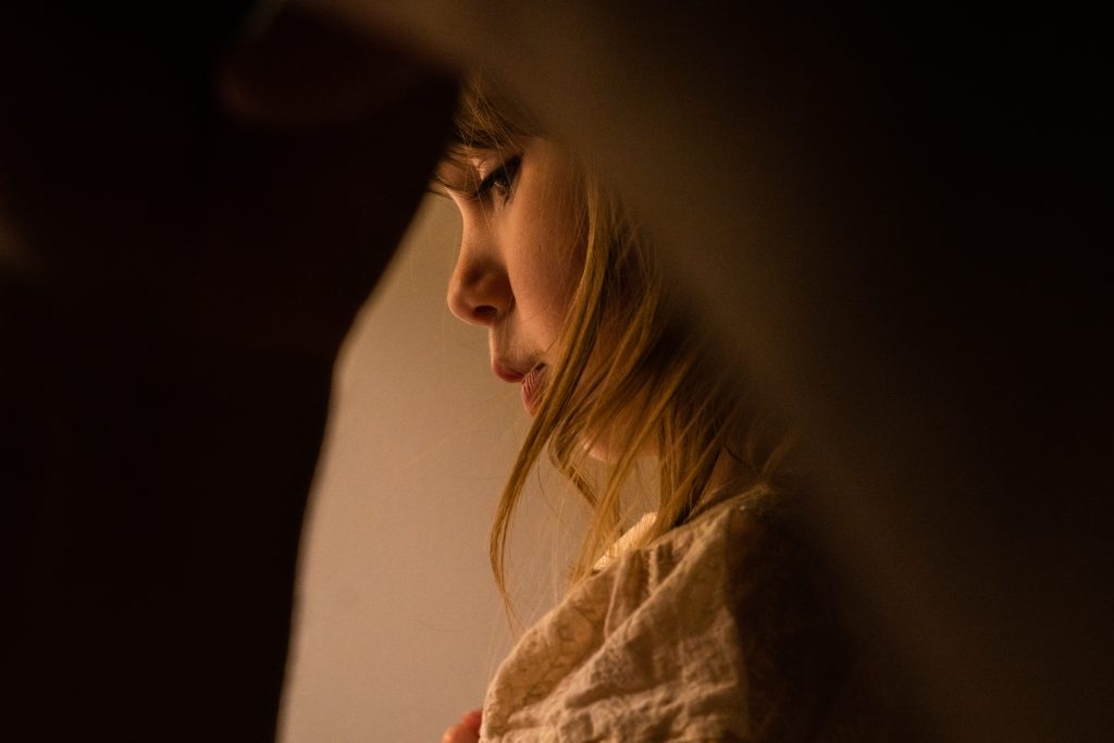 an award winning family photography portrait of a young girl through her Dads arm