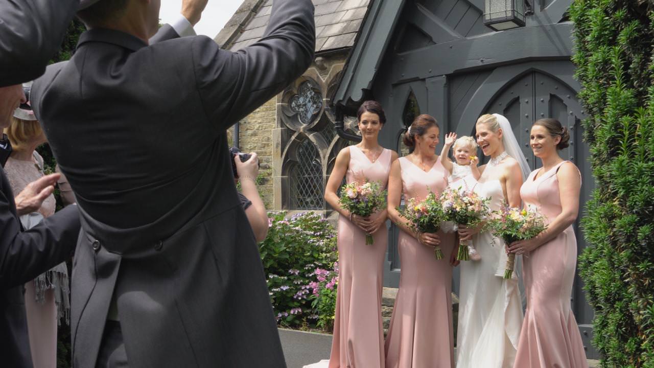 a bride and bridesmaids pose for the photographer and videographer in Dunham Massey