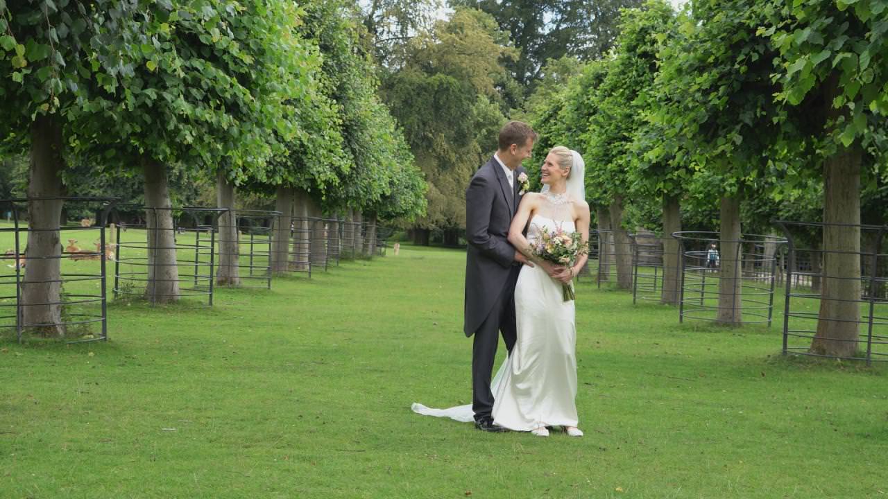 a bride and groom pose in the national trust gardens at Dunham Massey during their wedding