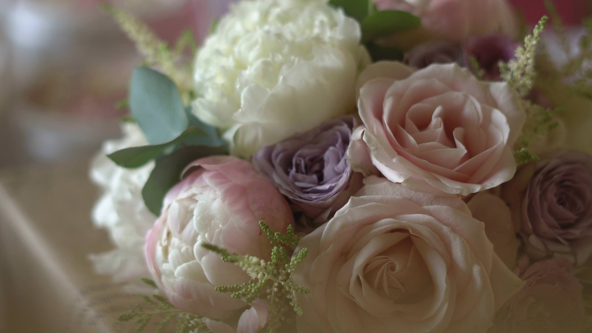 a close up of a bridal bouquet of peonies in pick and white