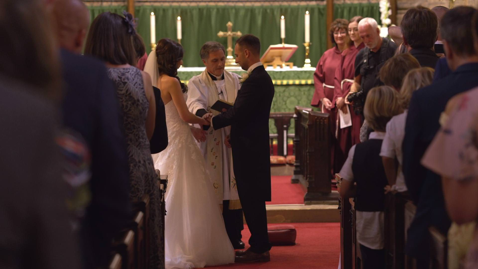 a bride and groom exchange wedding rings St Bartholomews and St John’s Church in lancashire