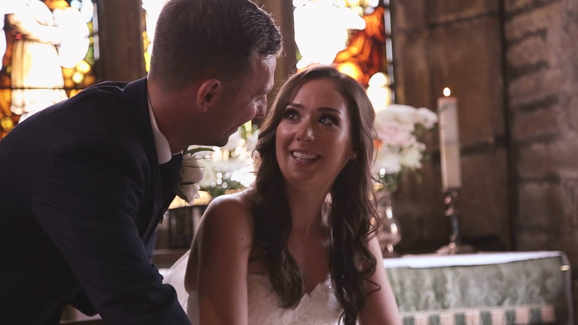 a bride looks up at her groom during the signing of the register