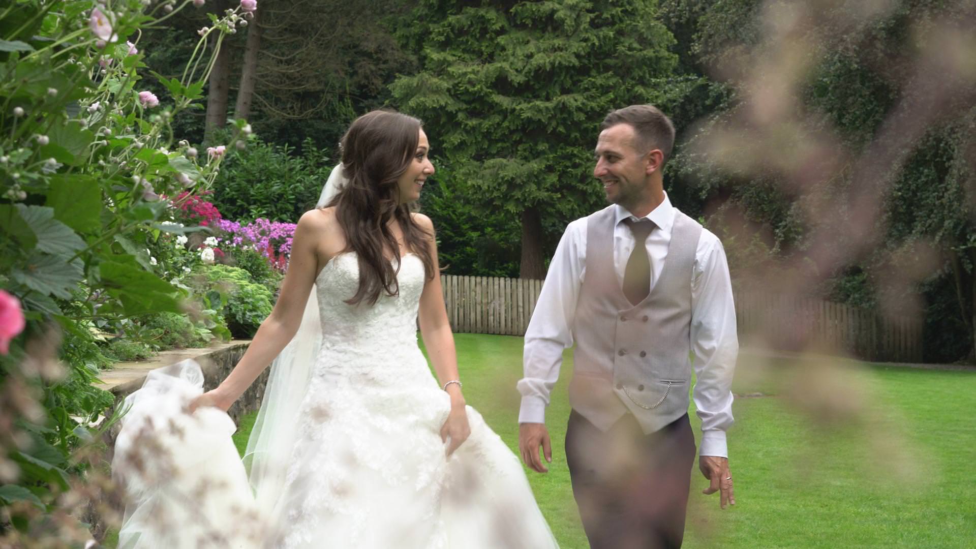 a bride and groom go for a relaxed walk at mitton hall for photos and video