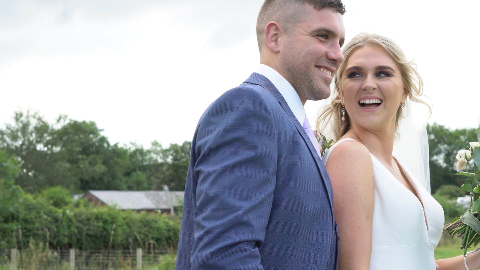 a video still of a bride laughing at her groom during their wedding photos in Lancashire