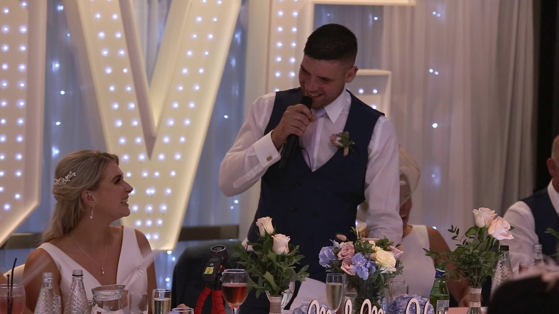 a groom laughs with his bride during his speech at Briars Hall