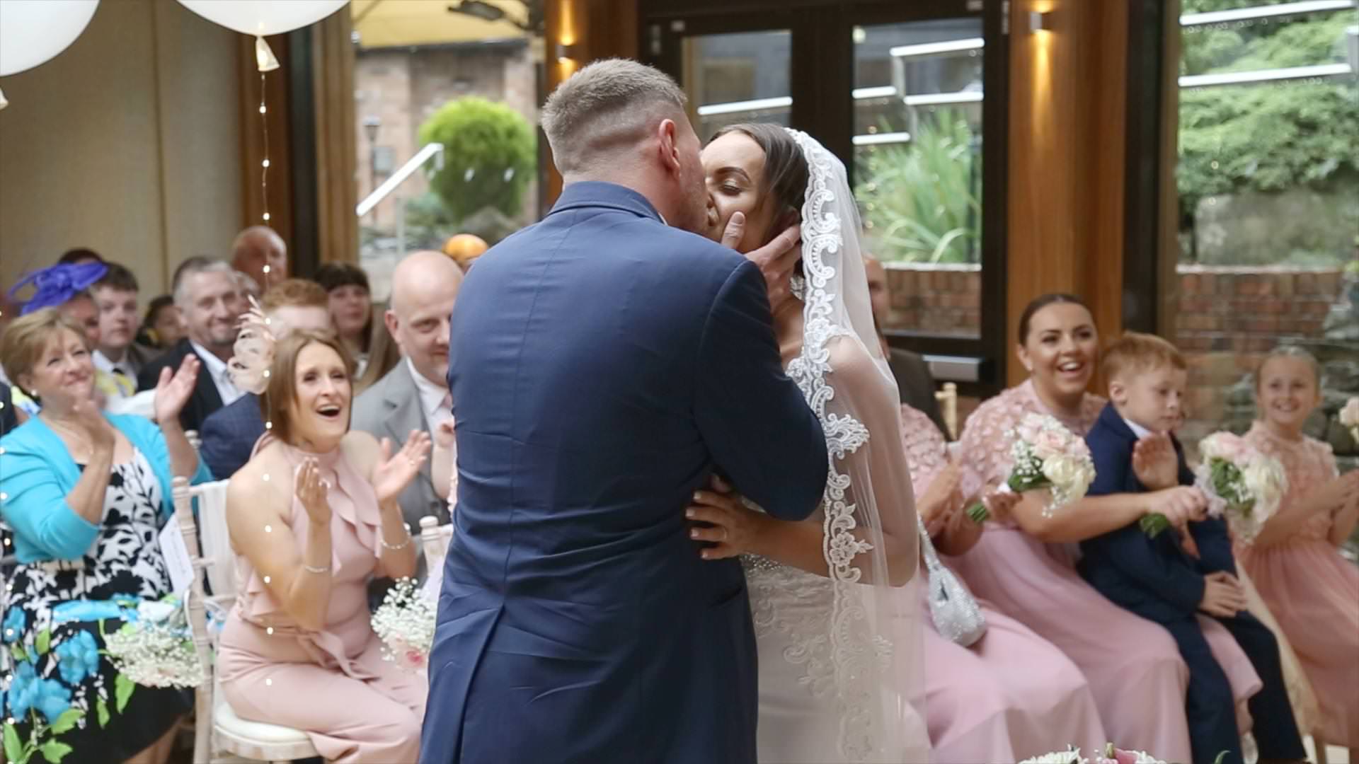bride and groom first kiss during a ceremony at Moddershall Oaks