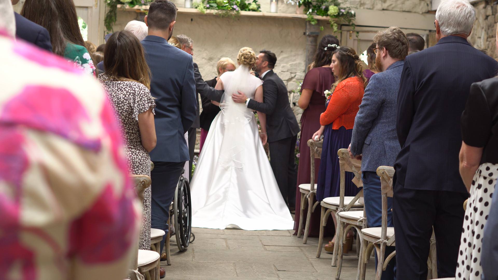 groom kisses the bride as they meet in the ceremony barn at Wyresdale