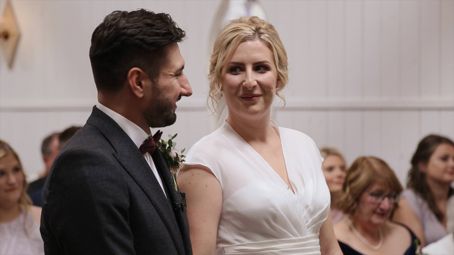 a groom smiles during a wedding ceremony reading at Wyresdale park