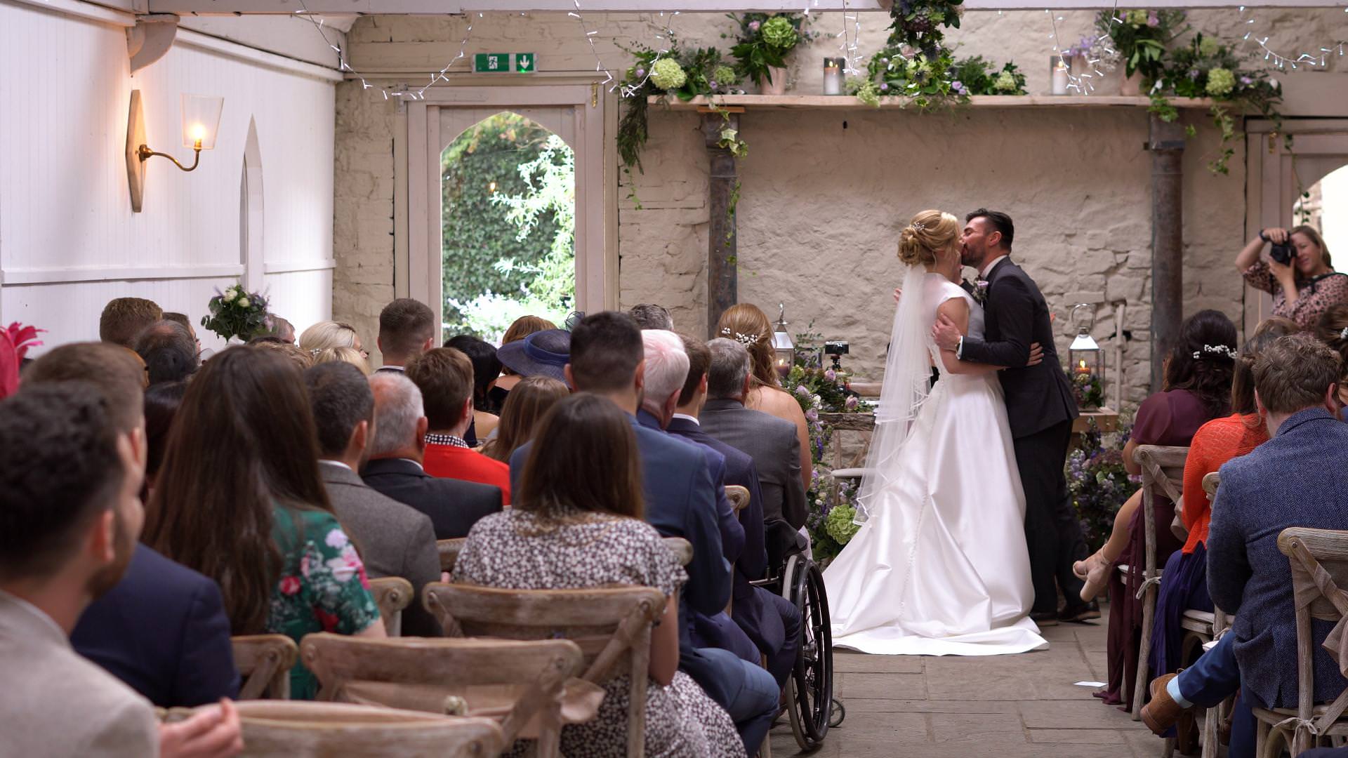 a video still of a bride and groom first kiss