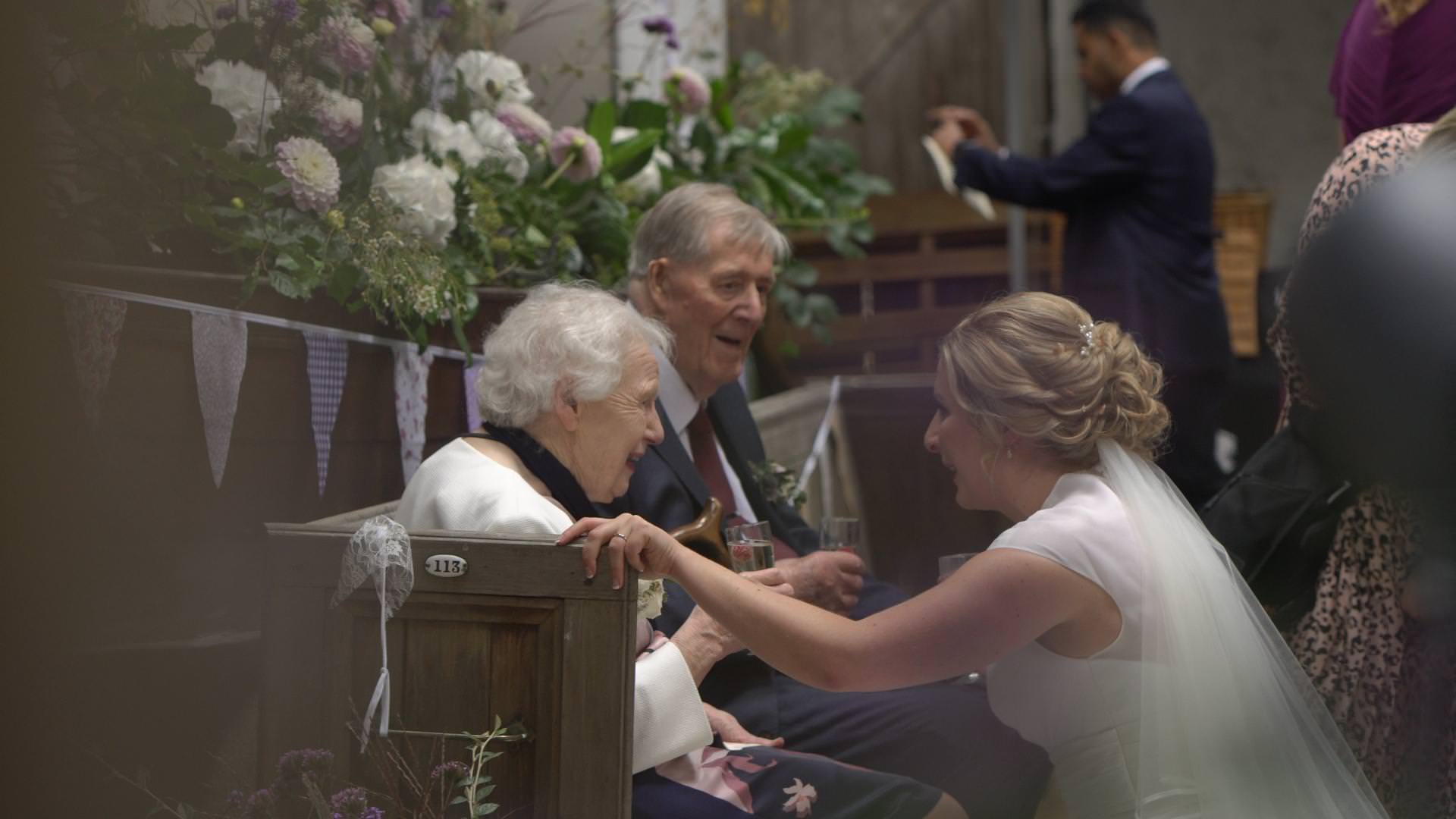 a bride crouches down to chat to her grandparents