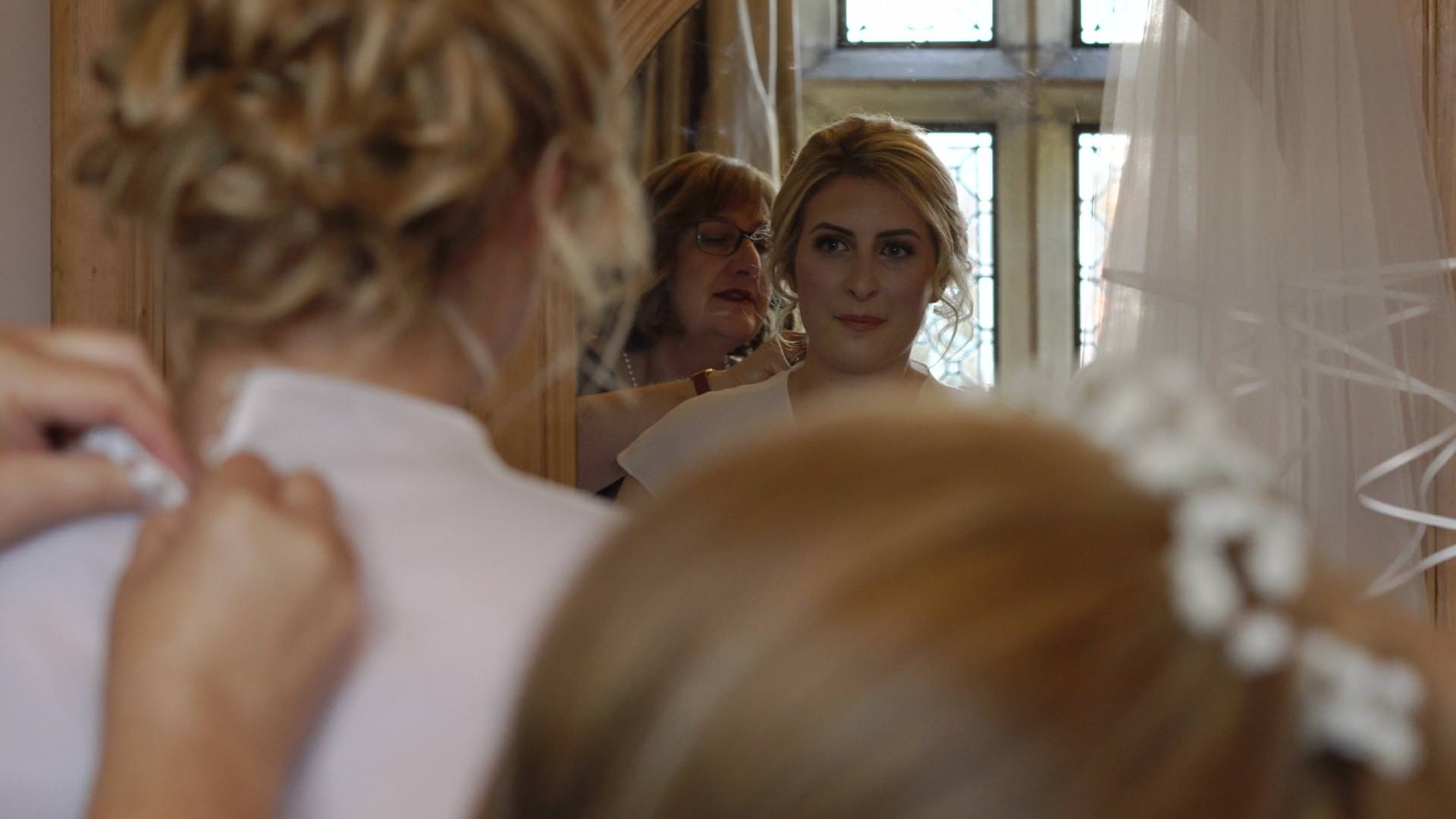 a bride looks at herself in a mirror in her dres at Wyresdale