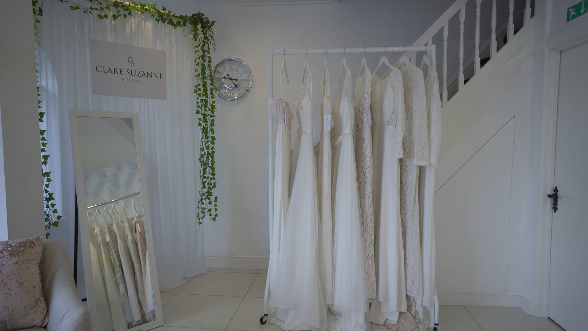 dresses hang neatly by a mirror at Clare Suzanne bridal in liverpool