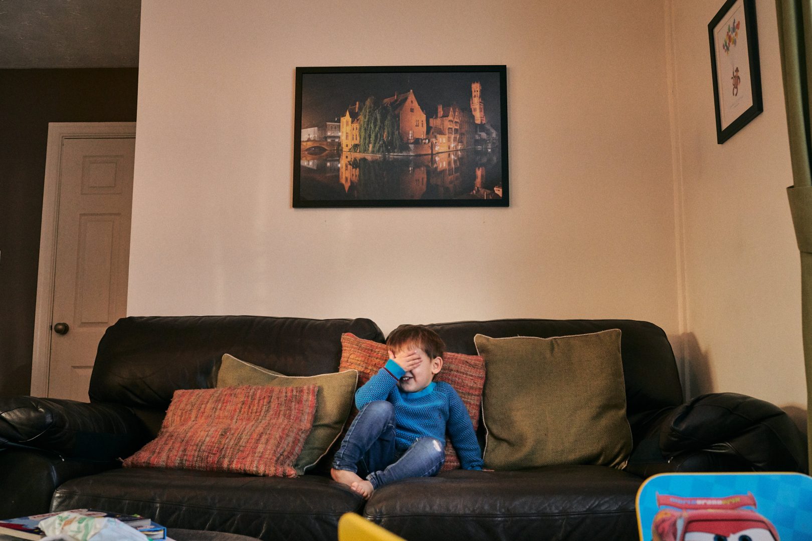 wide photo of boy with his hand over his face