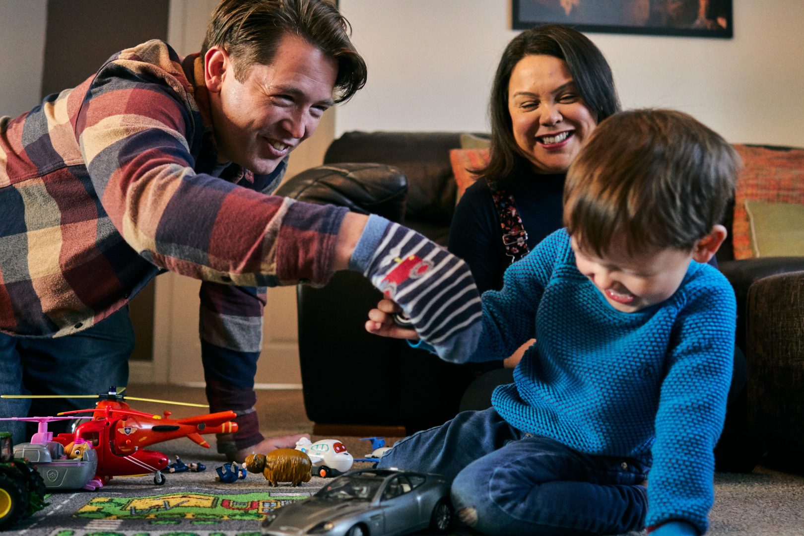 dad tickles son with a sock puppet during photoshoot