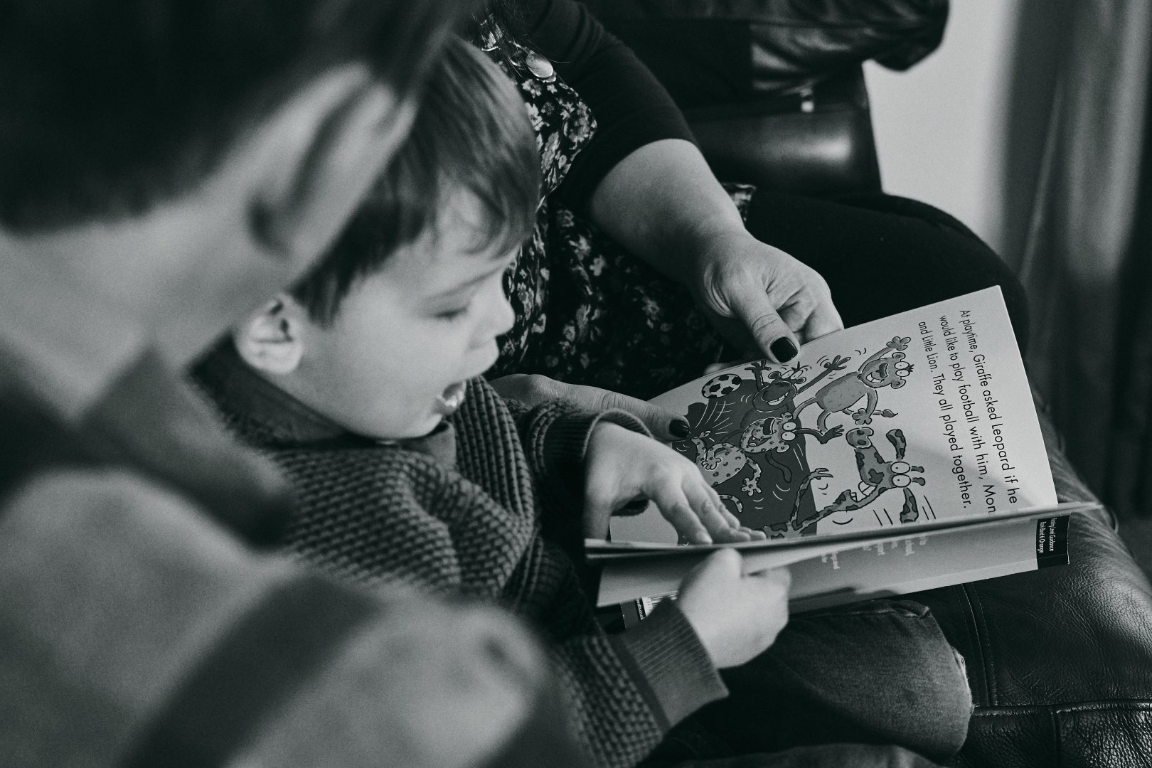 close up photograph of son reading a book to dad