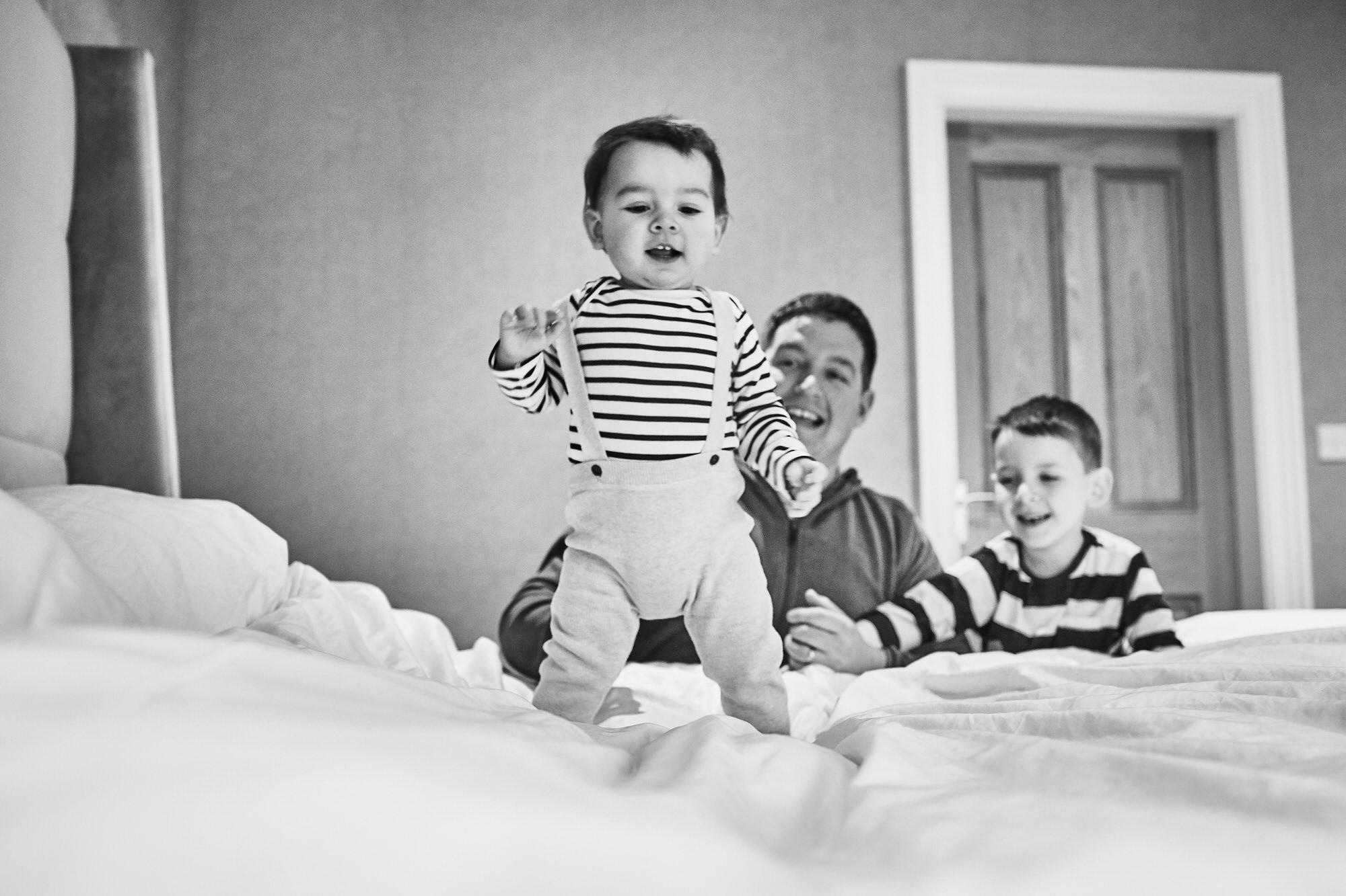 baby bouncing on parents bed at home