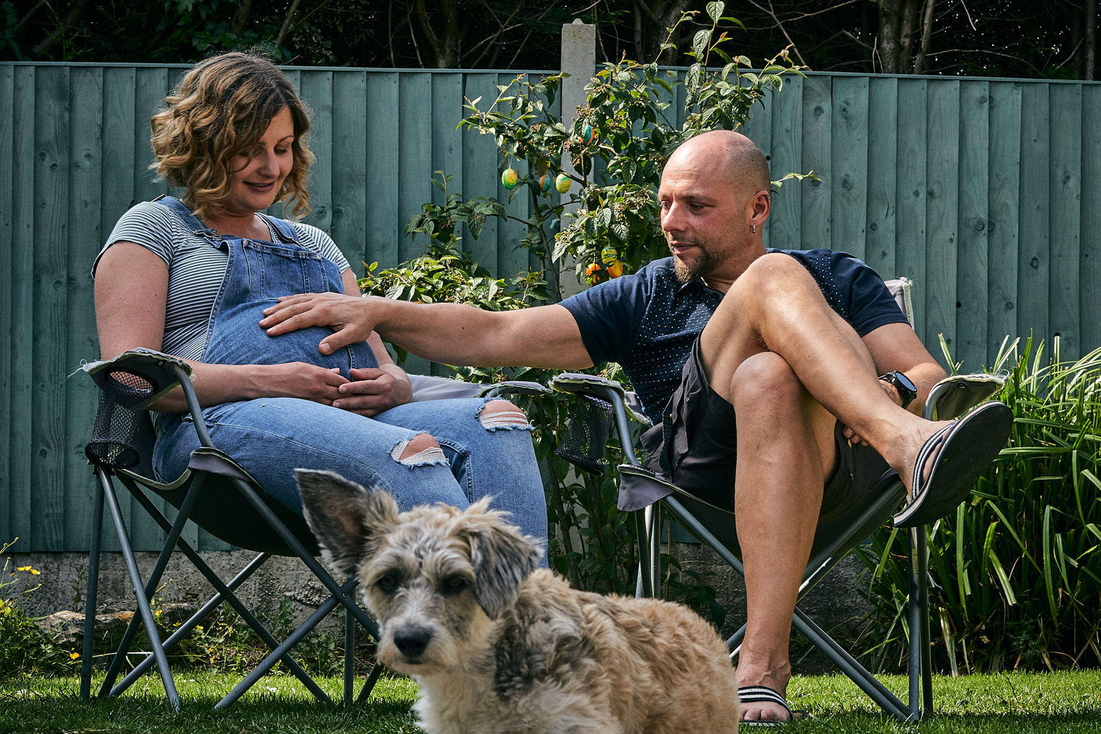 couple stroke baby bump during family photoshoot