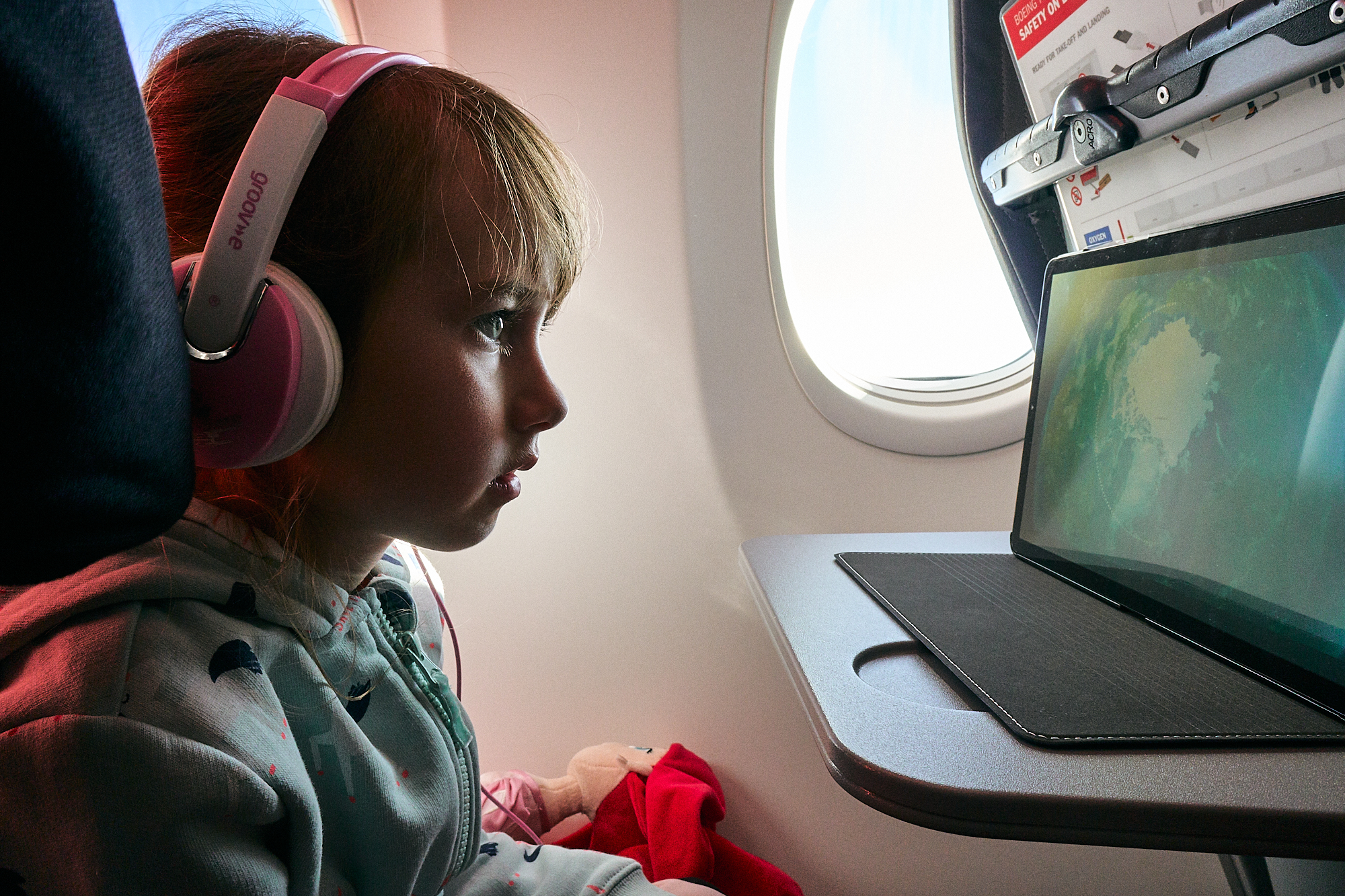 young girl watches tablet during flight to Turkey
