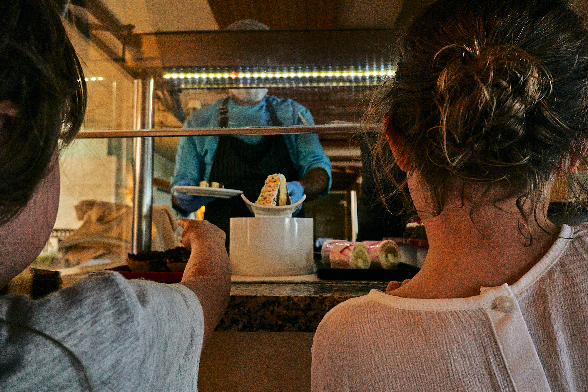 children reach for dessert from staff in PPE in Turkey