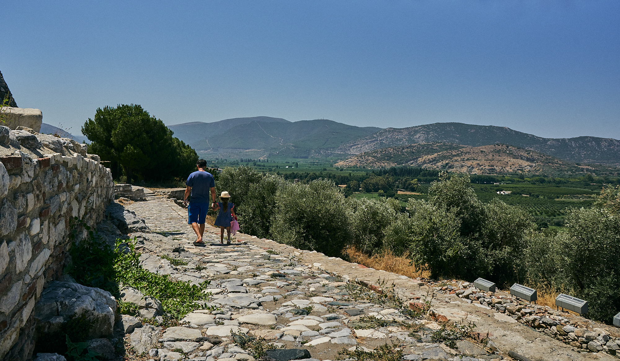 dad and daughter walk through ruins in Turkey