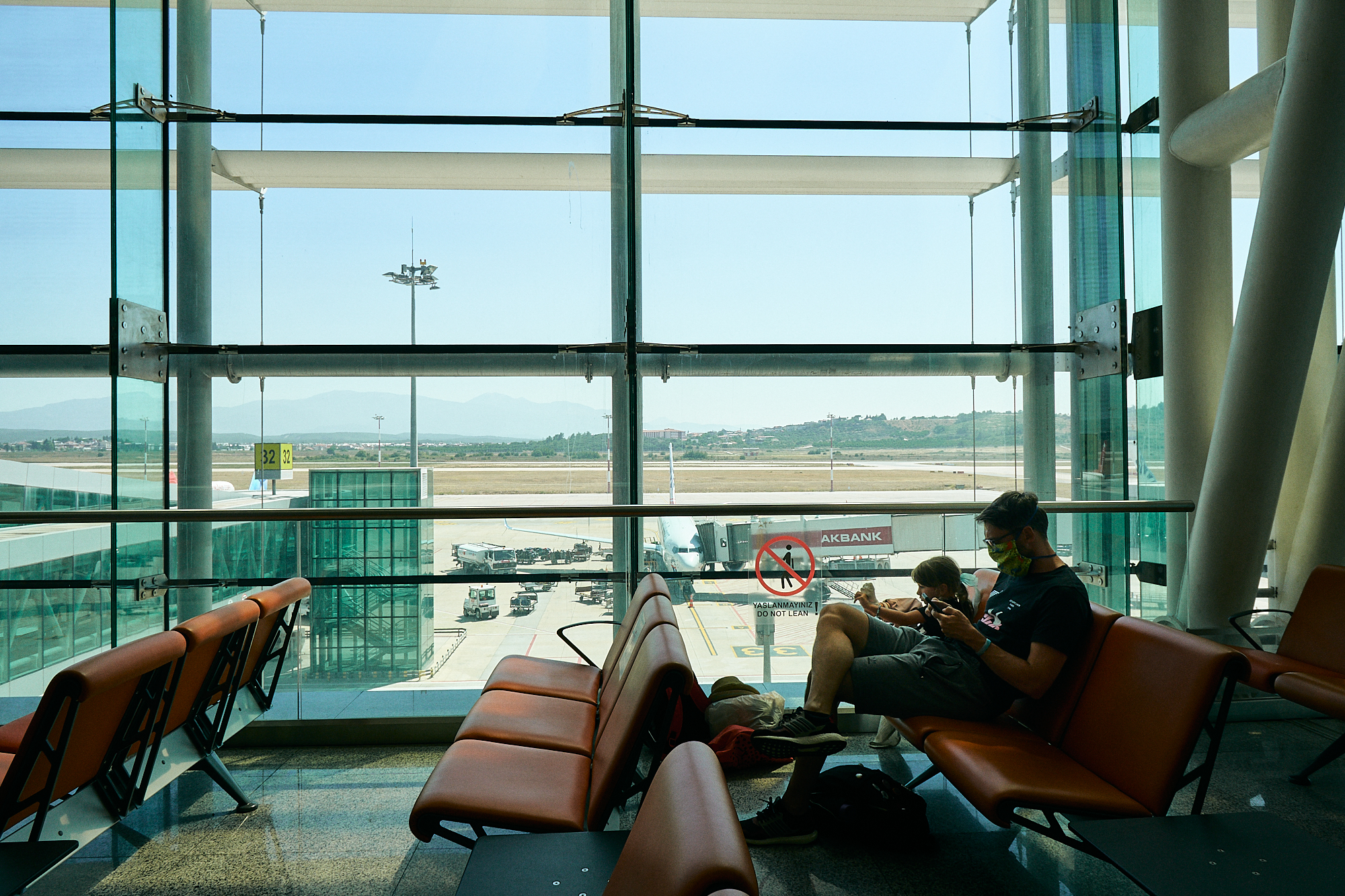 family sit and wait in quiet area in Ismir airport covid