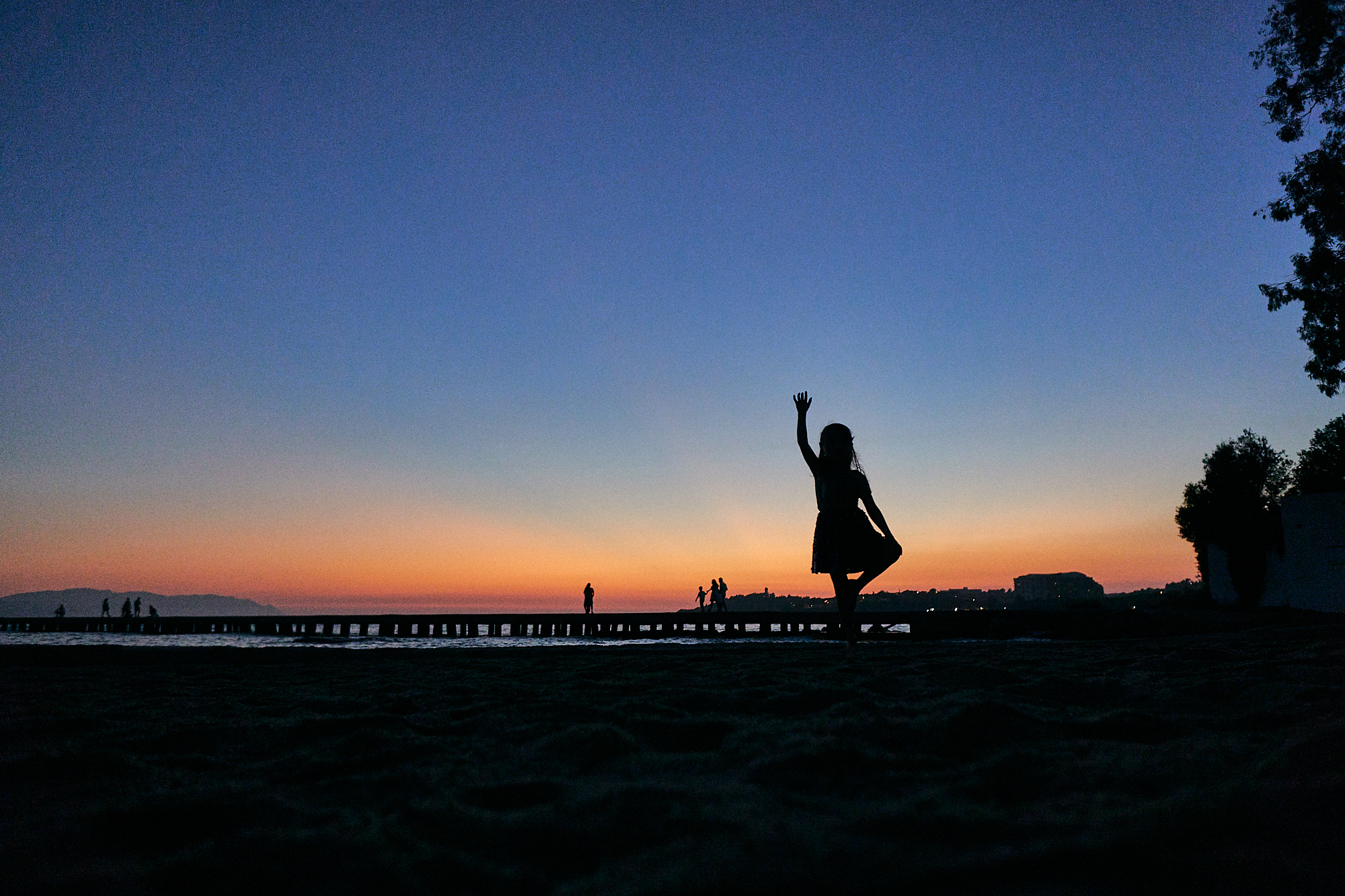 girl poses for family photo at sunset
