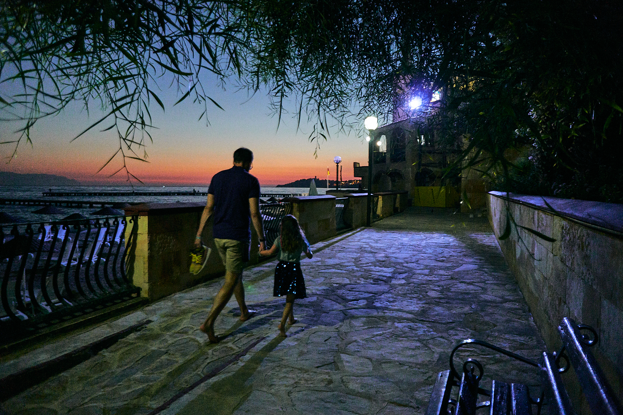 dad and daughter walk at sunset outside Fantasia Hotel