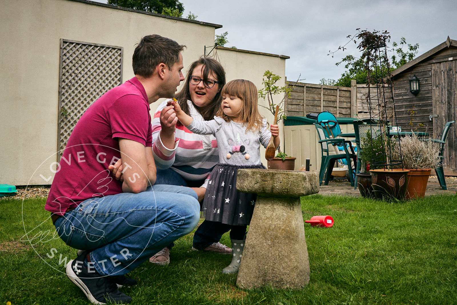 family playing with buttercups in garden for photoshoot
