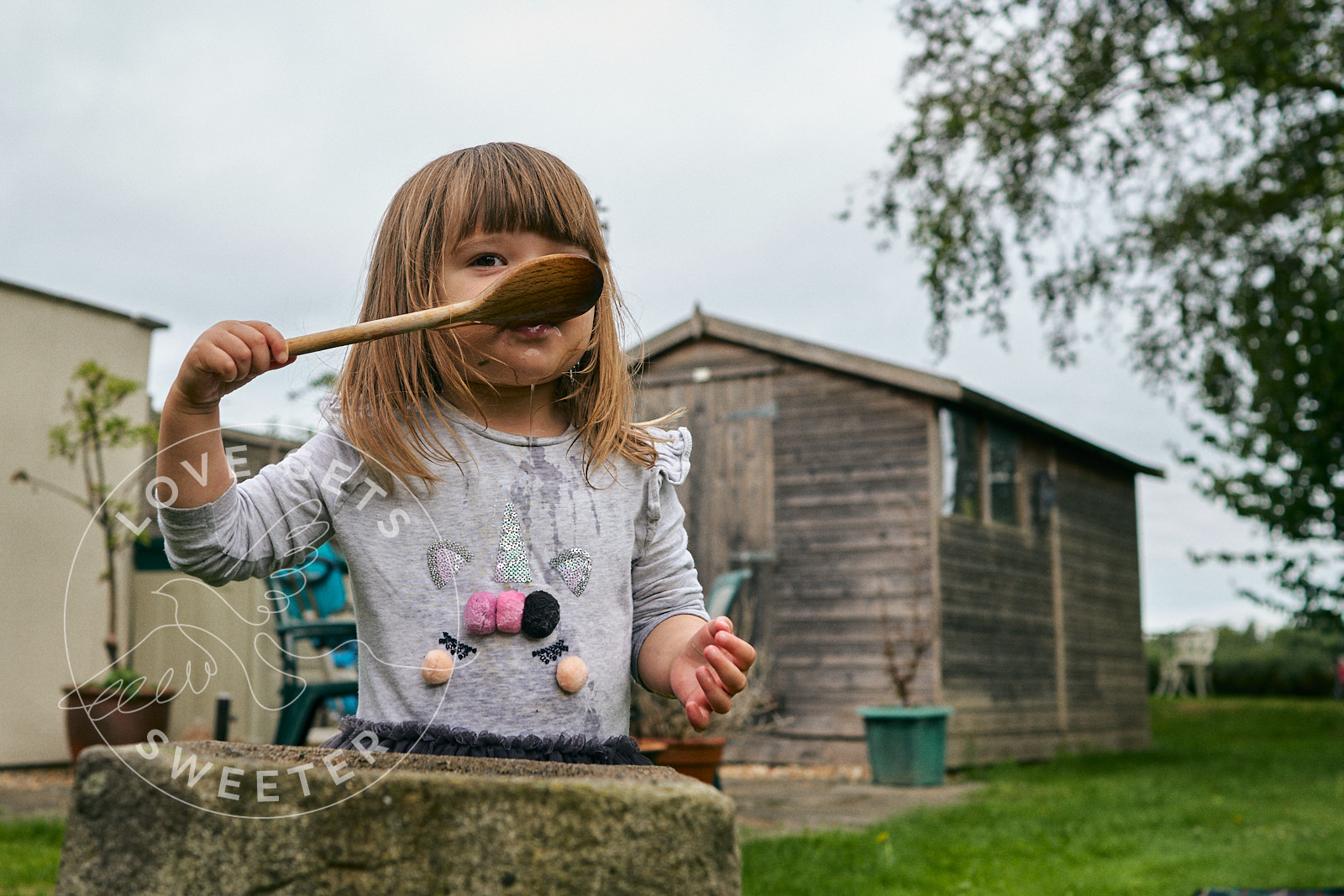 little girl gives cheeky glance to photographer