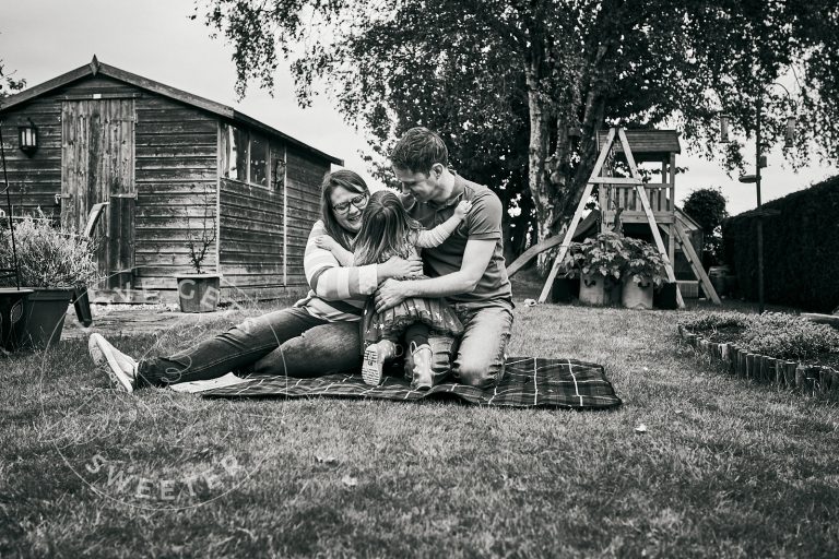 mum and dad get hug during outdoor family photoshoot