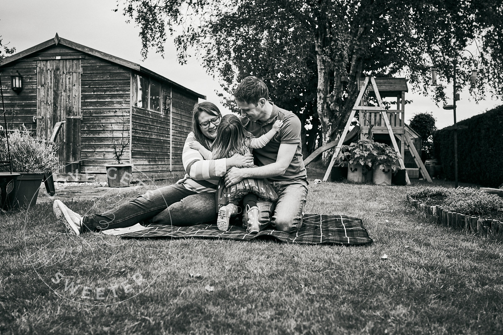 mum and dad get hug during outdoor family photoshoot
