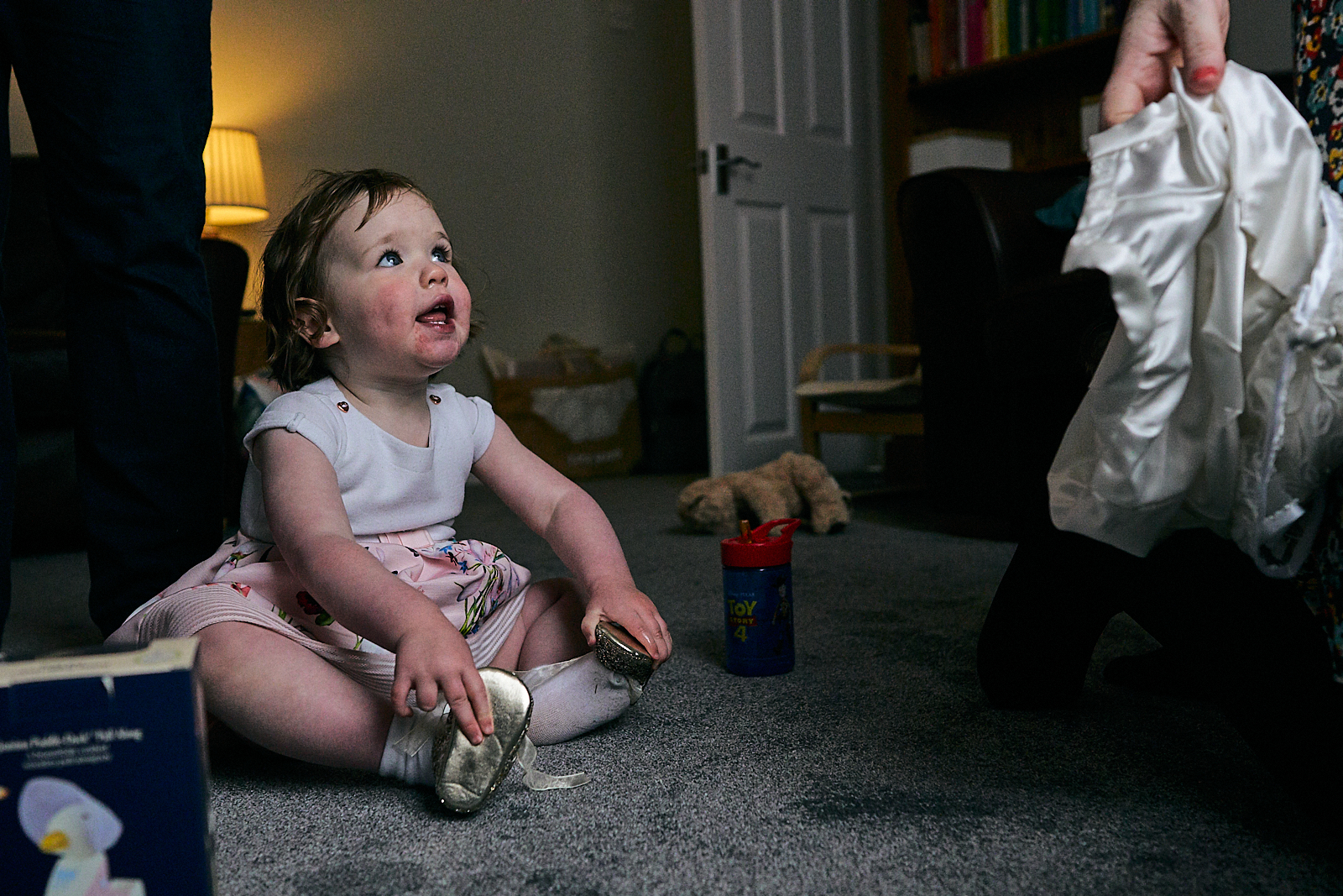 little girl tries on sisters glitter naming day shoes