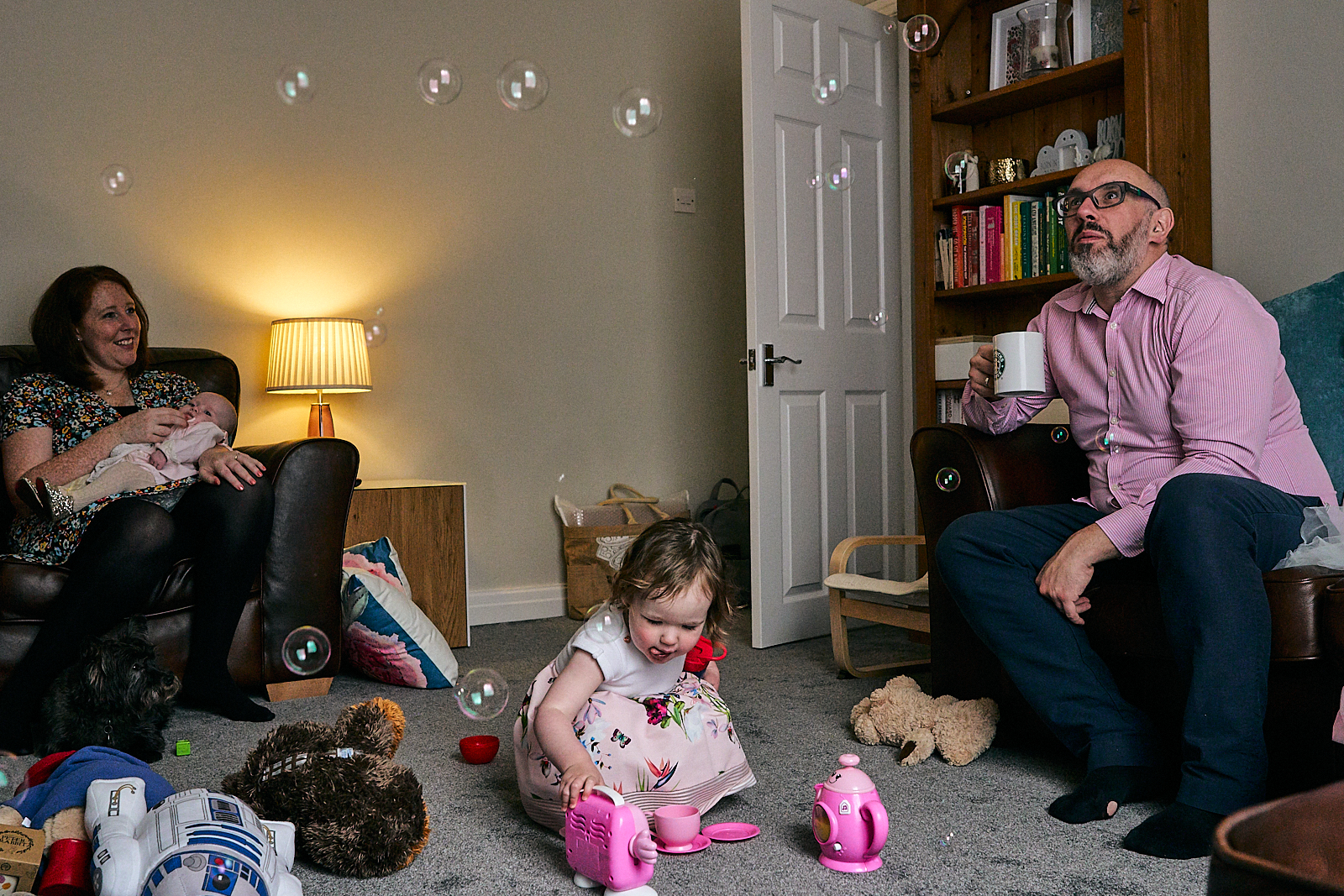 family sit in living room after naming ceremony in ramsbottom
