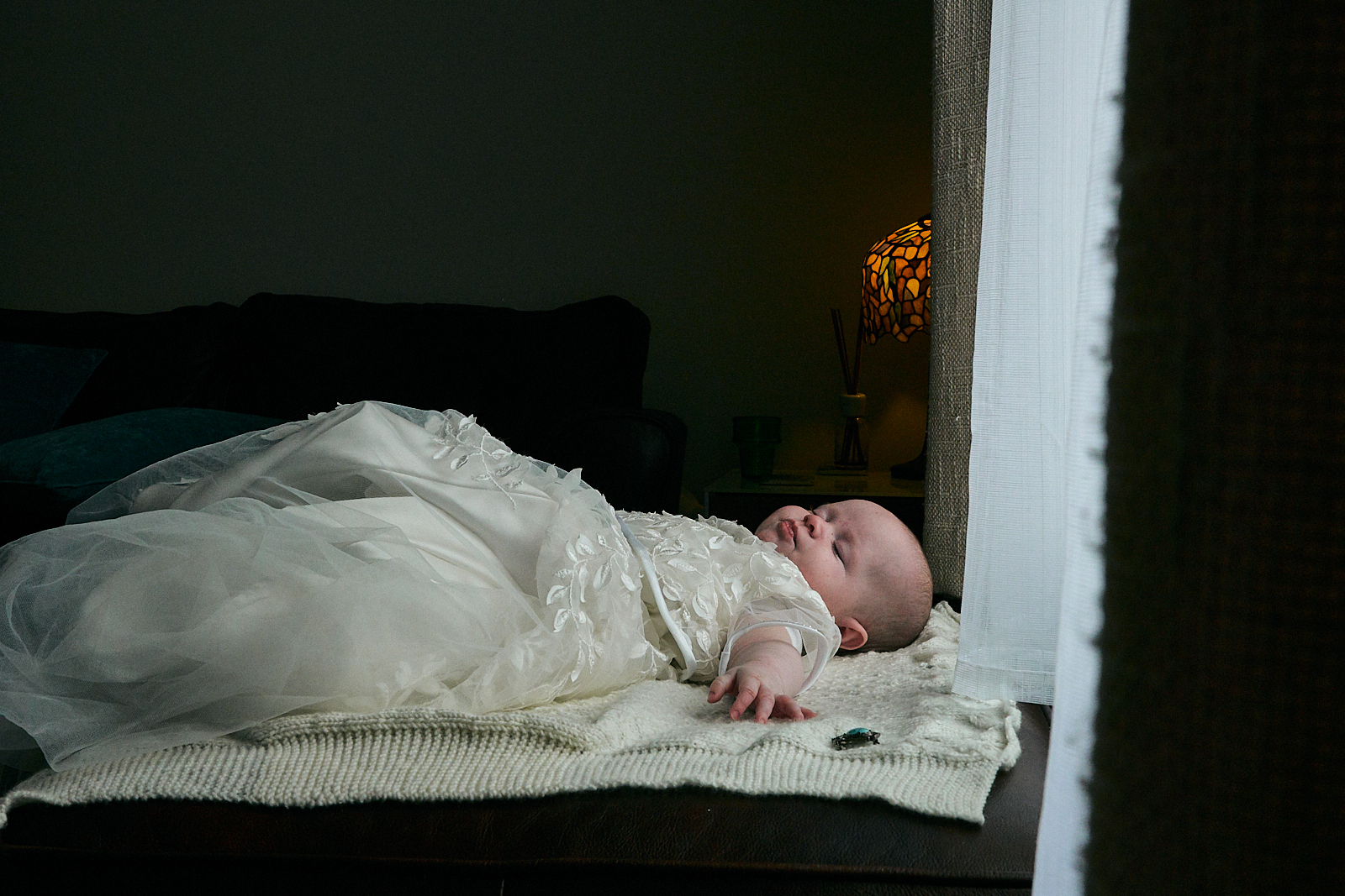 baby girl lays asleep in christening dress