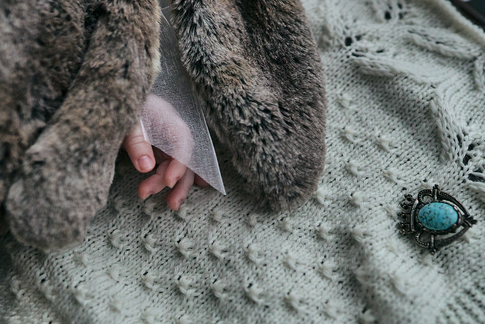 close up photo of baby girls hand on christening blanket