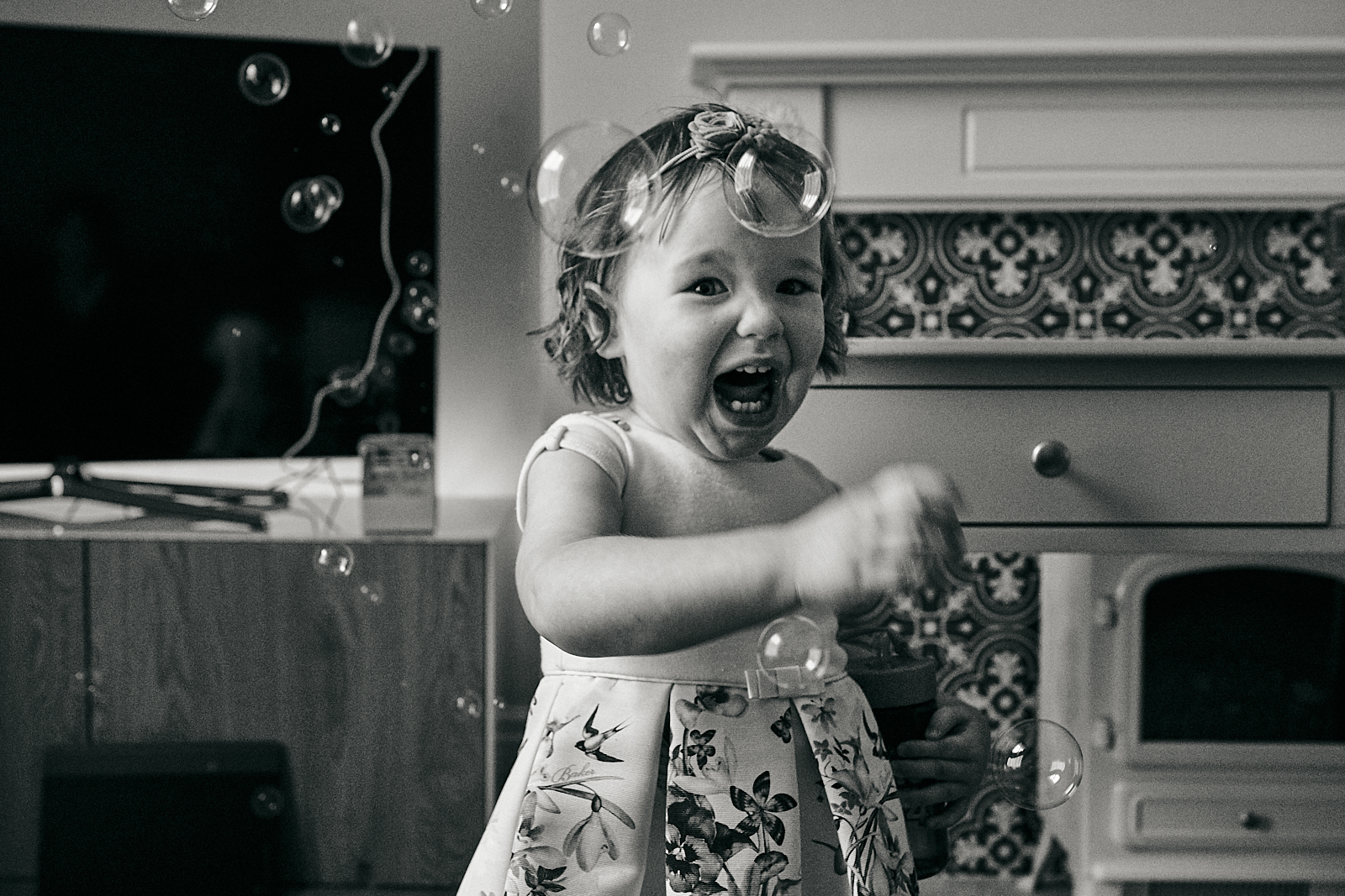 photo of little girl squeals at bubbles during naming day