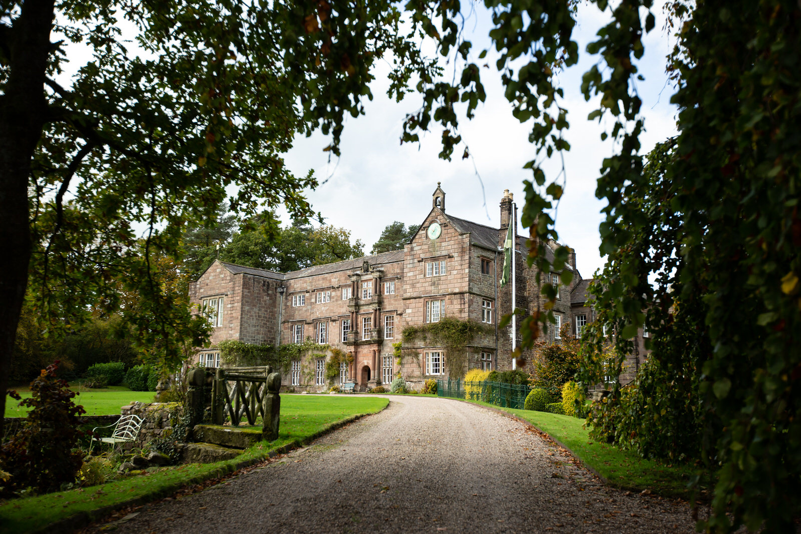 shot of Browsholme Hall through garden trees in Lancashire
