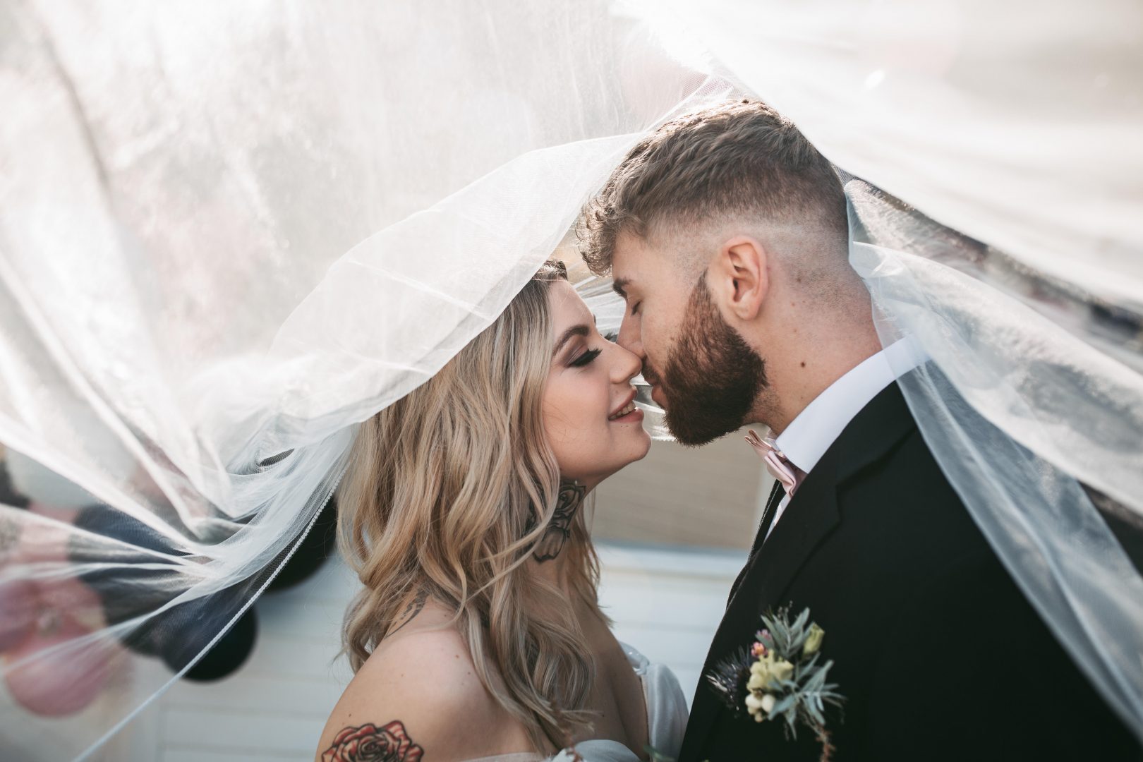 photo of bride and groom kiss under veil