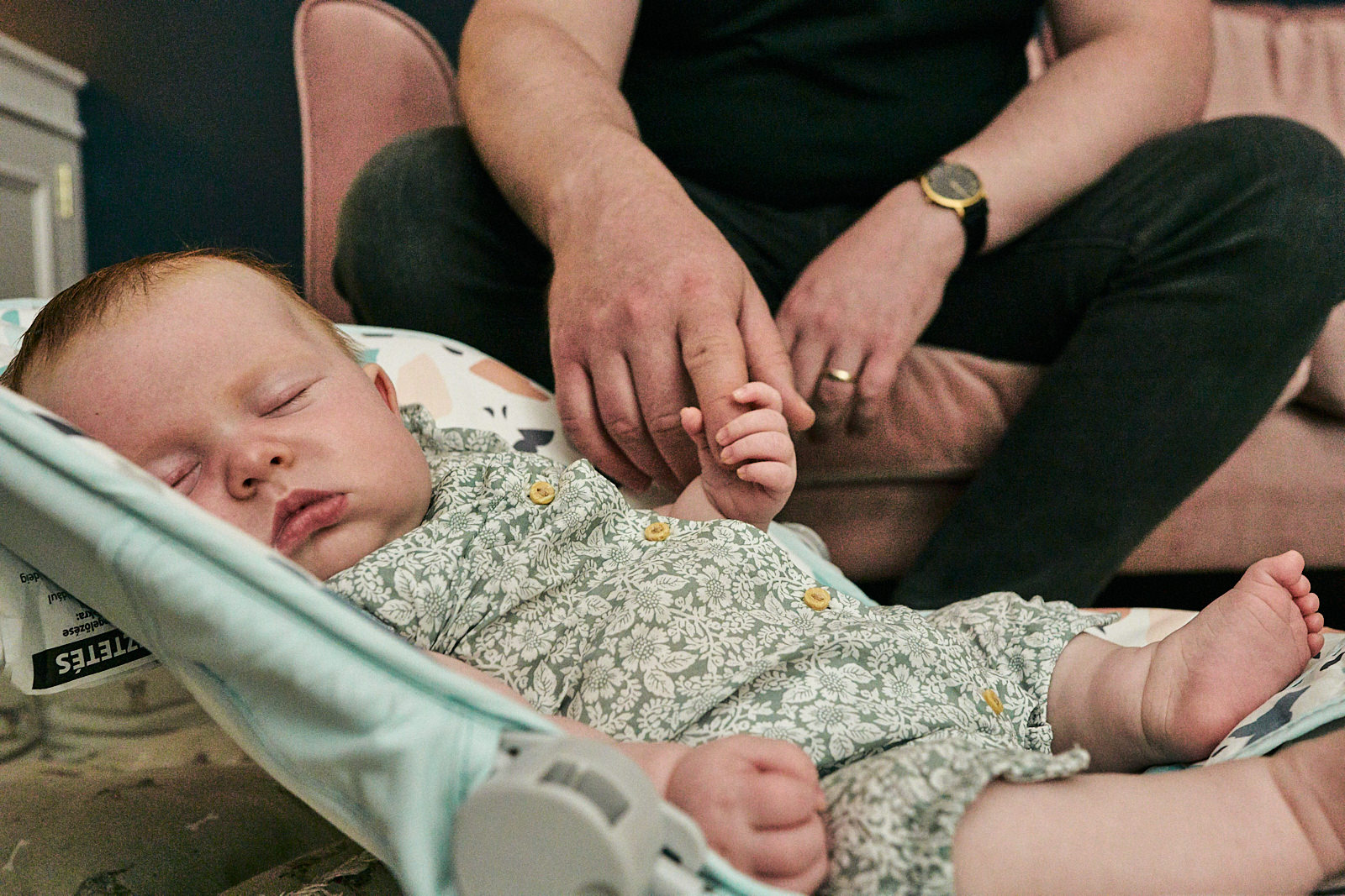 sleeping baby holding dads finger for natural photo